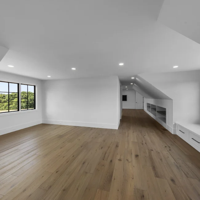 Bonus room with sloped ceilings and wood floors in Edgewater Estate, a custom home by Mike Stevens Homes