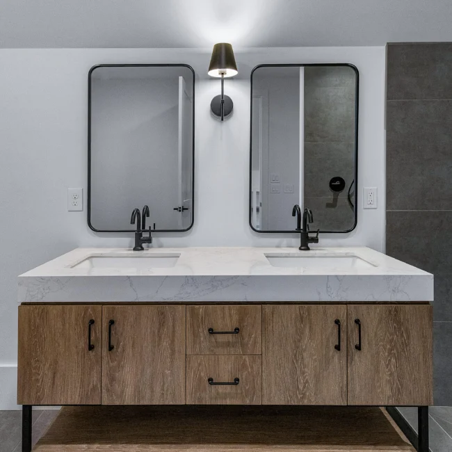 Double vanity with walnut base, black faucets and quartz top in Edgewater Estate, a custom home by Mike Stevens Homes