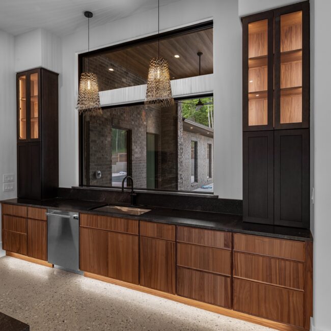 Kitchen sink wall with picture window and rattan pendants in Modern Prairie by Mike Stevens Homes