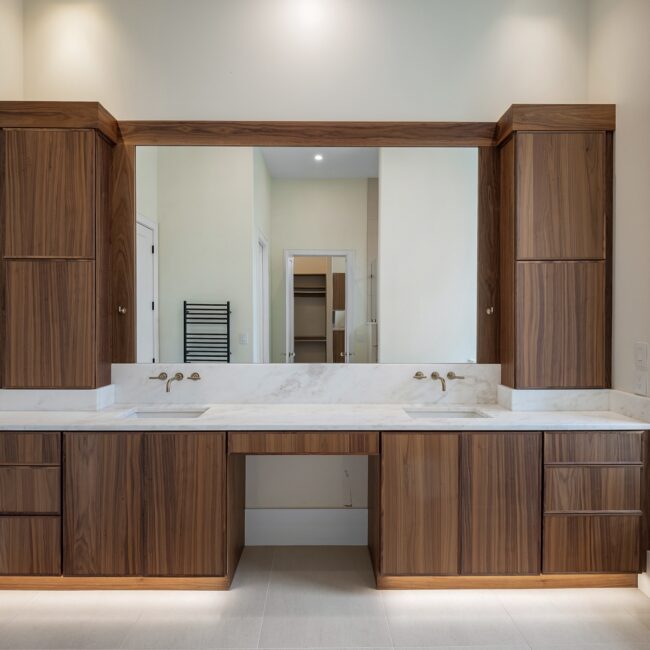Walnut double vanity with marble top in Modern Prairie, a custom home by Mike Stevens Homes