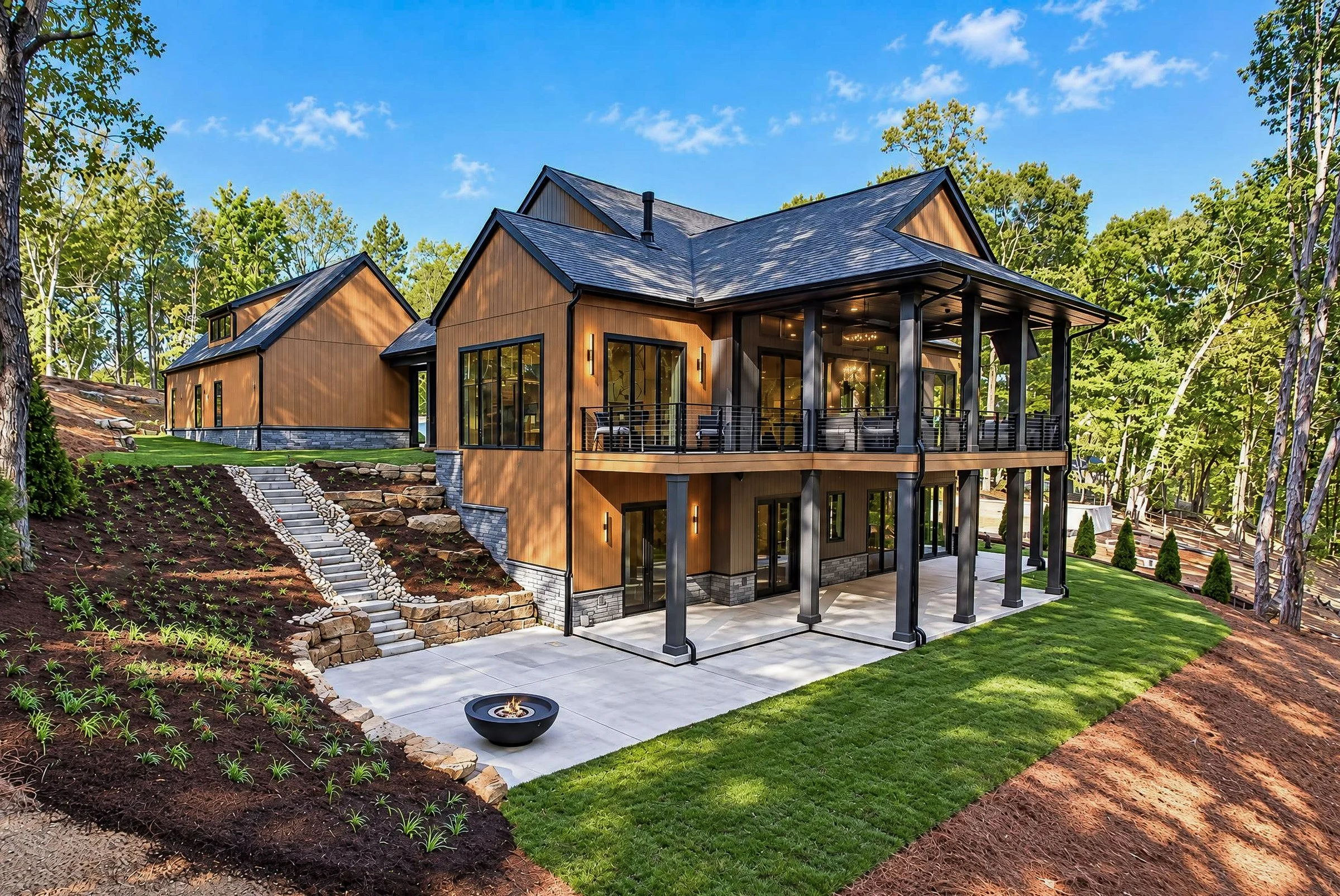 Rear of cedar-clad home with covered deck and stone steps in Shino No Mori, a custom home by Mike Stevens Homes