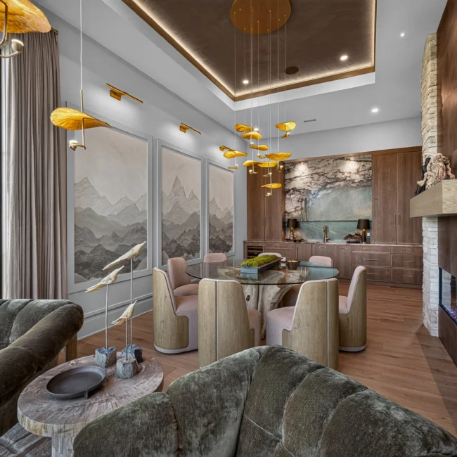 Sunset Heights dining area from the nook with green velvet chairs in front, tall windows at left and mountain murals