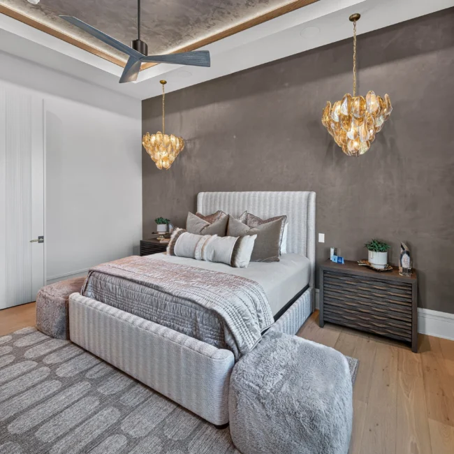 Sunset Heights primary bedroom with a plaster tray ceiling, ceiling fan, a striped upholstered bed and two gold chandeliers